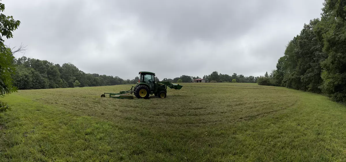 Tractor bush hogging an overgrown field